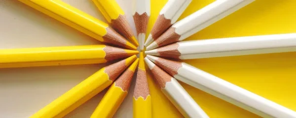 White and yellow pencils fanning out in circle and integrating