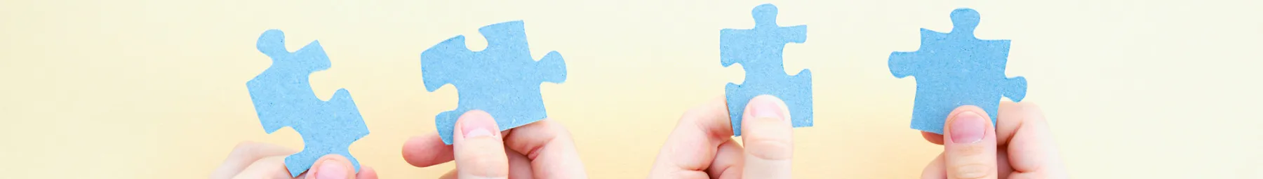jigsaw pieces being held up to join together