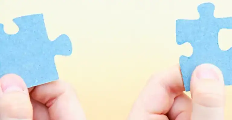 jigsaw pieces being held up to join together