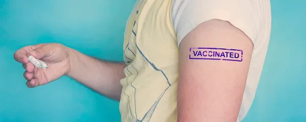 man with vaccinated stamp on arm