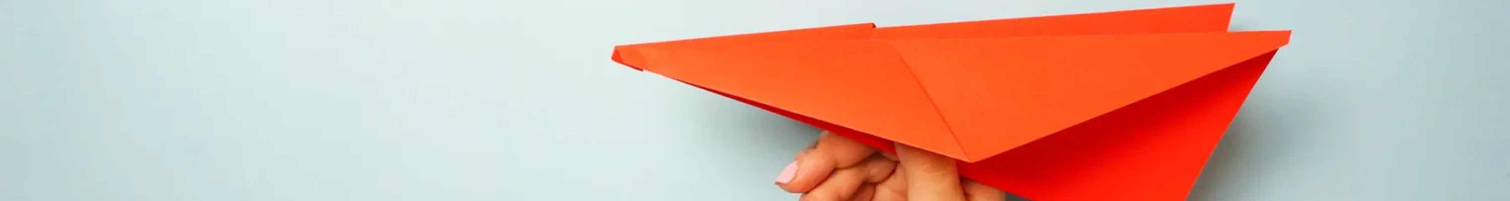 Red paper aeroplane being held
