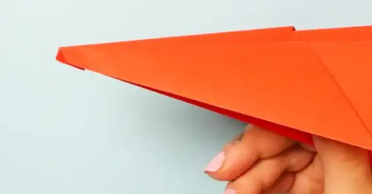 Red paper aeroplane being held