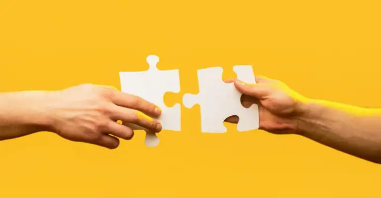 Two Arms With Jigsaw Puzzle Pieces Yellow Background