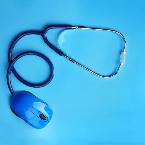 Blue stethoscope attached to computer mouse blue background (1)