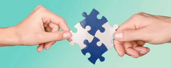 4 pieces of jigsaw held up by two hands