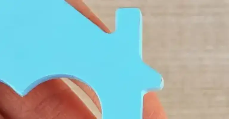 open hand holding wooden flat shape of house with heart shape cut out