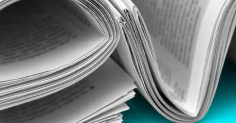 Rolled up newspaper used to write out news