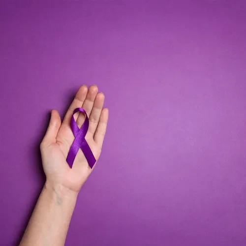 Hand holding purple ribbon on a purple background resized
