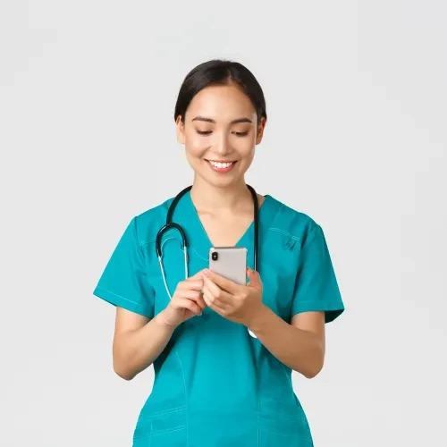 Doctor holding and looking at phone smiling