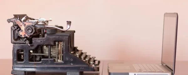 typewriter and computer facing each other