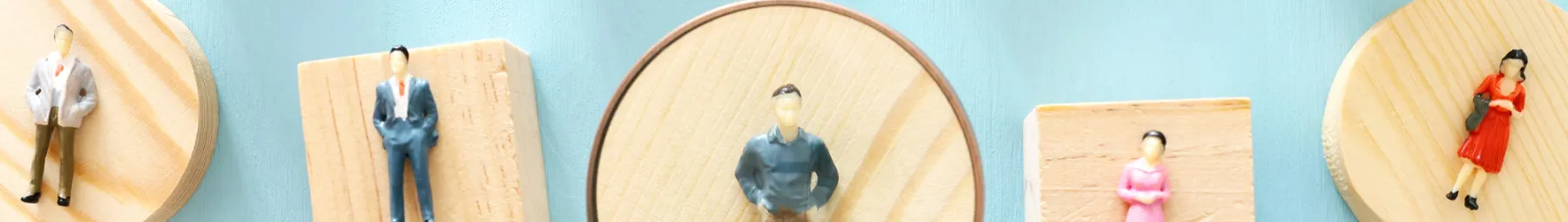 Wooden toy people under a magnifying glass resized