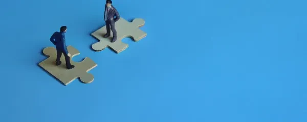 two figure people on jigsaw pieces